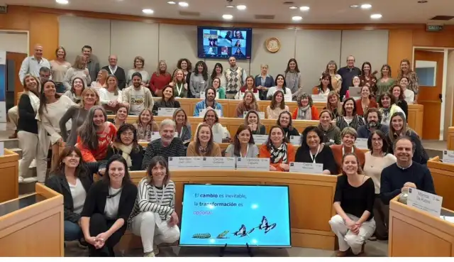 Foto grupal de participantes de un encuentro en un auditorio.