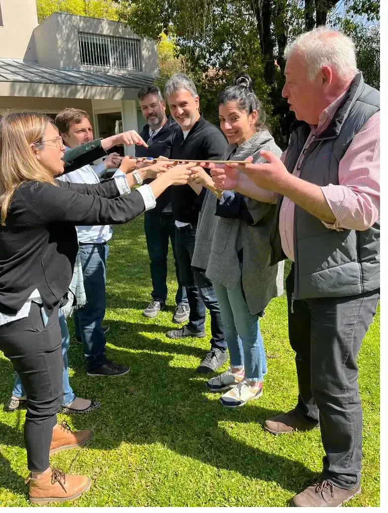Grupo coordinando sus movimientos con las manos en una dinámica al aire libre.