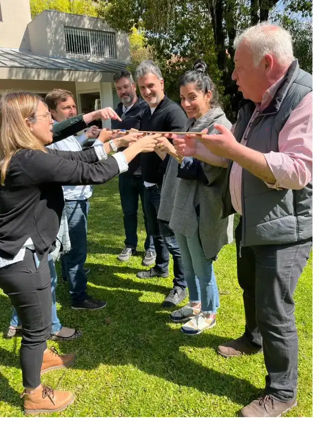 Grupo coordinando sus movimientos con las manos en una dinámica al aire libre.